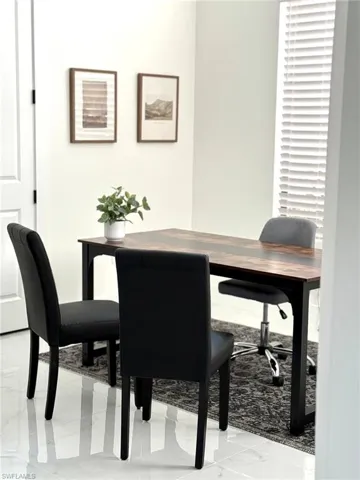 Dining space featuring light marble finish floors