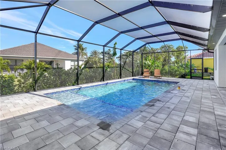 Outdoor pool featuring a sunroom, a lanai, and a patio area