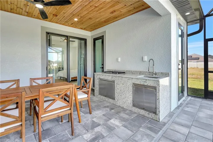 View of patio featuring outdoor dining area, area for grilling, and a ceiling fan