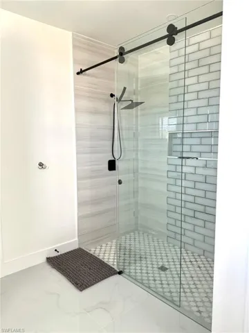 Bathroom featuring a shower stall and baseboards