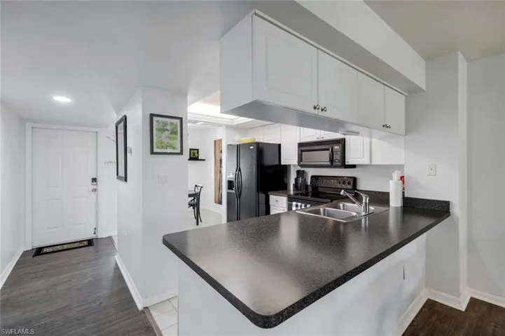 Kitchen with dark countertops and white cabinetry