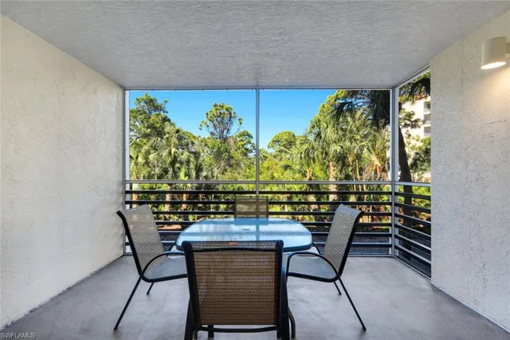 Screened balcony featuring textured walls and a textured ceiling