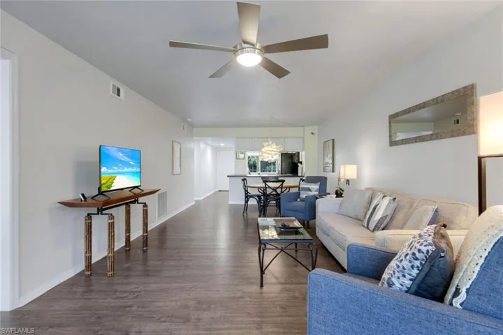 Living area featuring wood-finish flooring, a contemporary ceiling fan, and light-toned walls