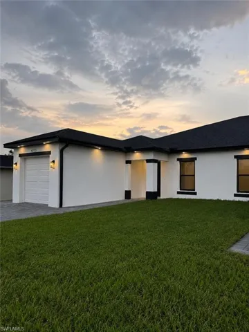 Modern single-story residence with a white exterior and contrasting black trim