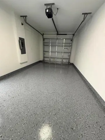 Garage featuring a speckled epoxy floor finish and white painted walls