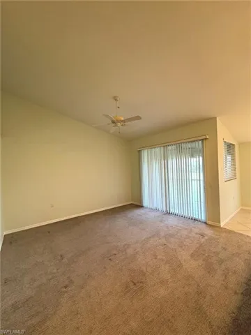Carpeted spare room featuring baseboards and ceiling fan