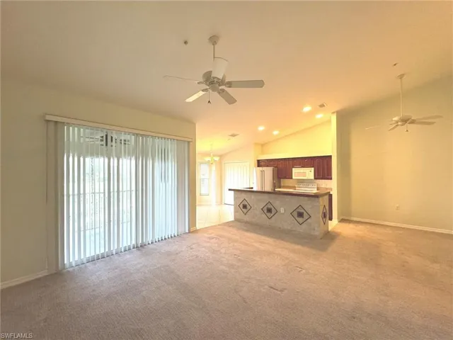 Unfurnished living room featuring a ceiling fan, lofted ceiling, light carpet, and recessed lighting