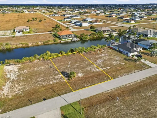 Aerial perspective of suburban area featuring property boundaries highlighted and a large body of water