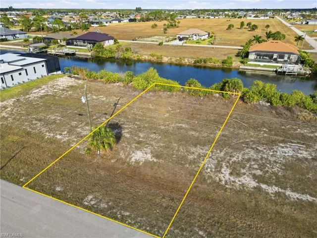 Aerial view of residential area featuring property parcel outlined and a nearby body of water