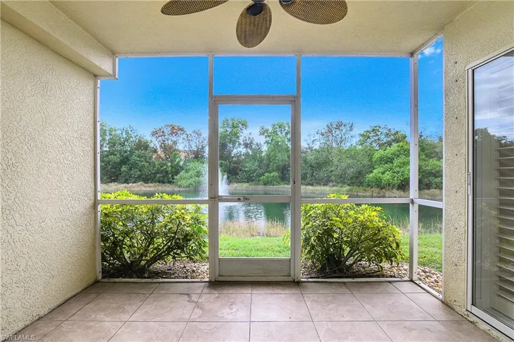 Unfurnished sunroom featuring ceiling fan and a water view