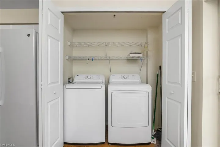 Washroom with washer and clothes dryer and laundry area