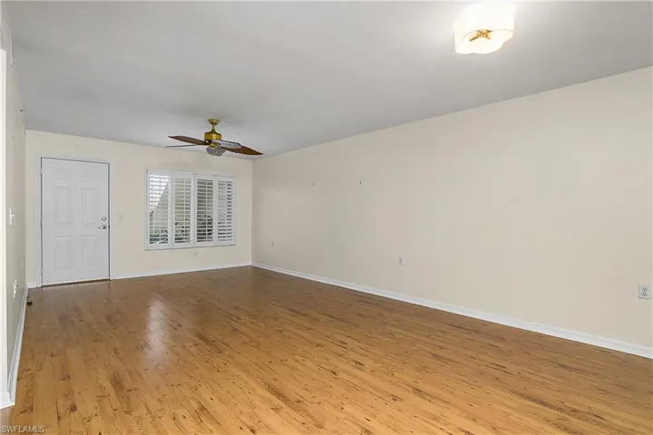 Empty room with light wood-style flooring, baseboards, and a ceiling fan