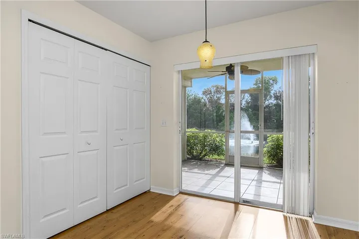 Doorway featuring baseboards, wood finished floors, and ceiling fan