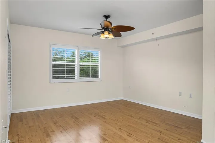 Empty room featuring ceiling fan, wood finished floors, and baseboards