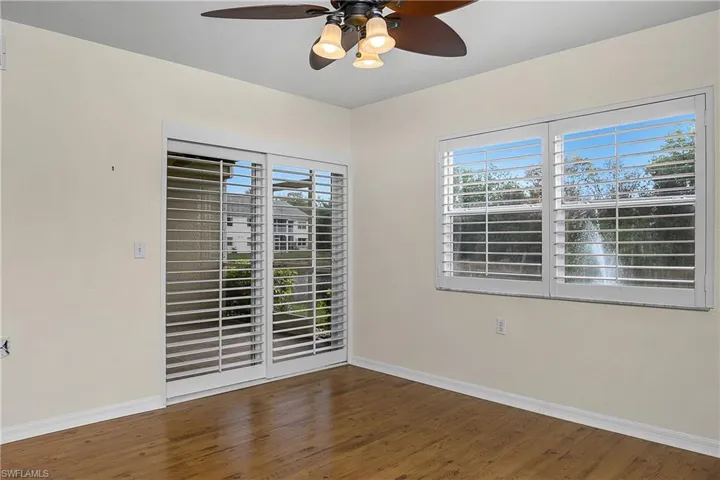 Spare room featuring wood finished floors, ceiling fan, and baseboards