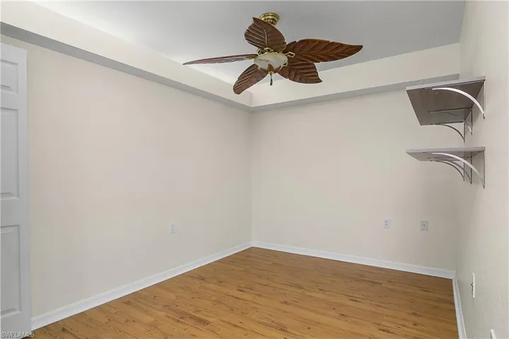 Spare room featuring ceiling fan, light wood-type flooring, and baseboards