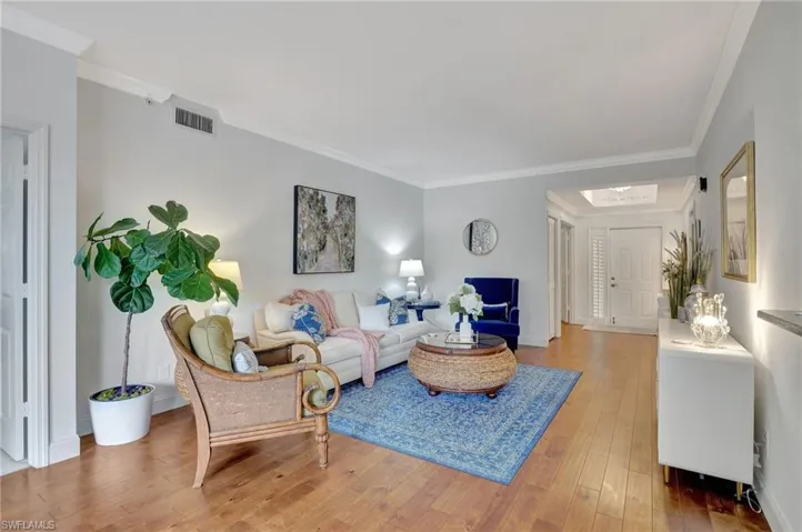 Living room with crown molding and hardwood / wood-style floors
