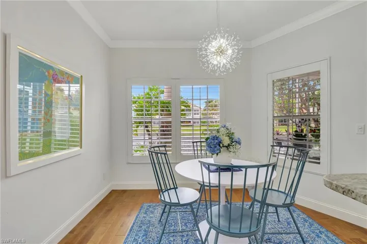 Dining space featuring hardwood / wood-style floors, a chandelier, and ornamental molding
