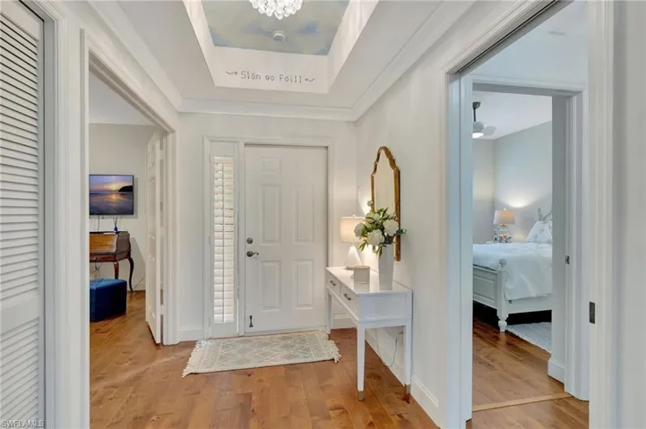 Entrance foyer with a notable chandelier and light hardwood / wood-style flooring