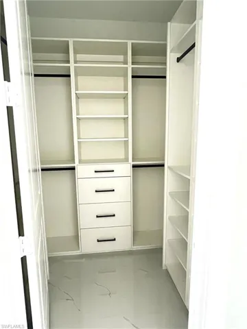 Walk in closet featuring custom cabinetry