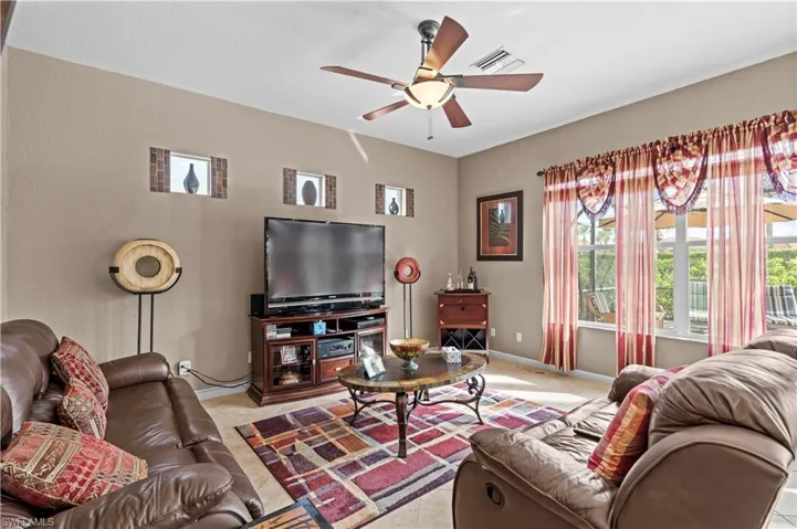 Living room with ceiling fan and light carpet
