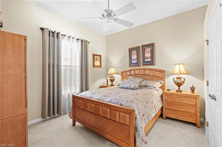 Bedroom with ceiling fan and light colored carpet