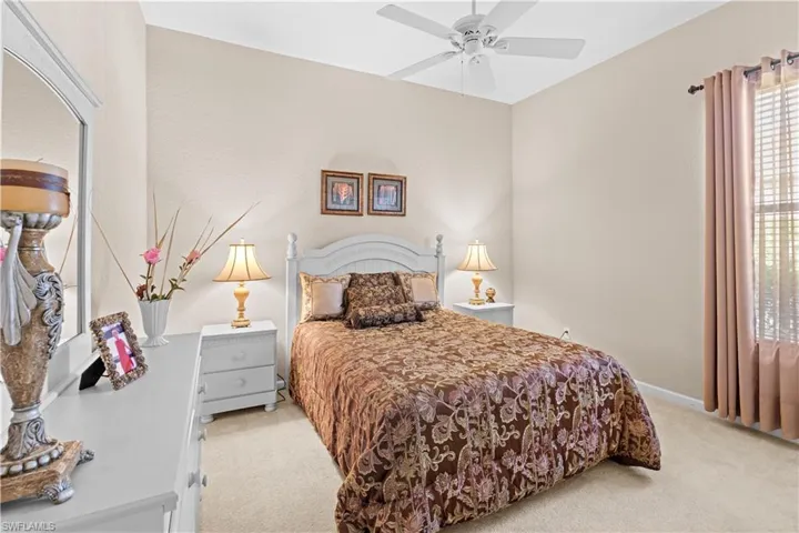 Carpeted bedroom featuring ceiling fan