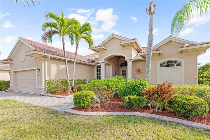 Mediterranean / spanish house featuring a garage and a front lawn