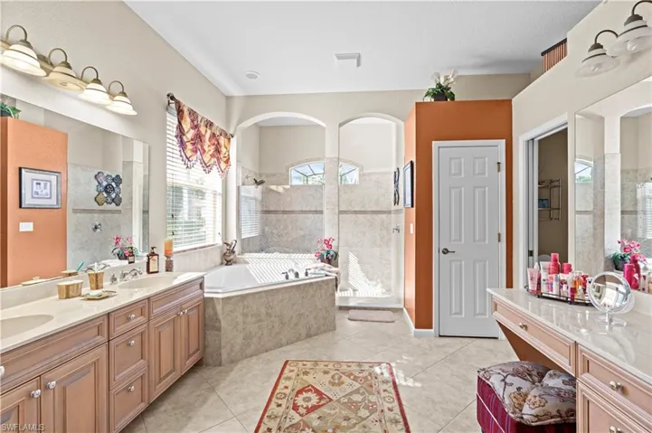 Bathroom featuring separate shower and tub, vanity, and tile patterned flooring