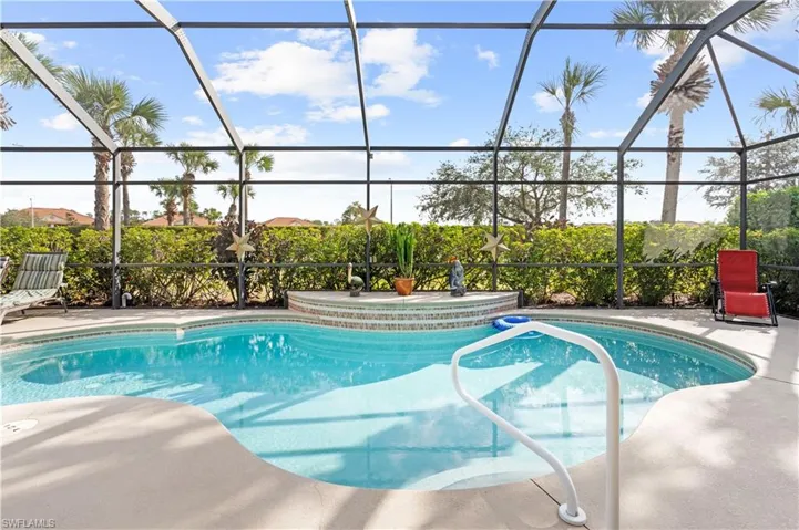 View of pool with glass enclosure and a patio