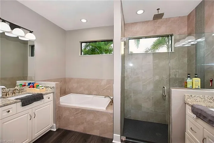 Bathroom with vanity, independent shower and bath, and hardwood / wood-style floors