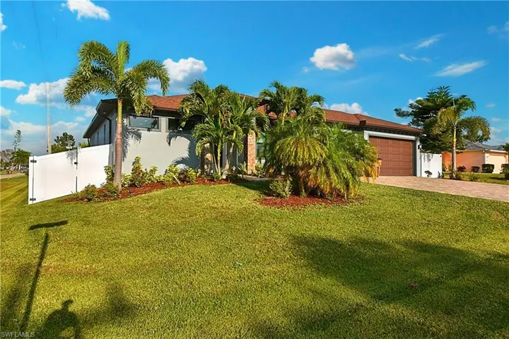 View of front of house with a garage and a front lawn