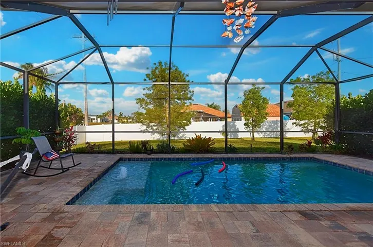 View of pool with a patio area and screened enclosure