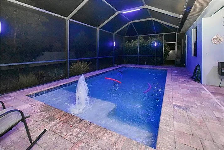 View of swimming pool featuring a patio area and glass enclosure