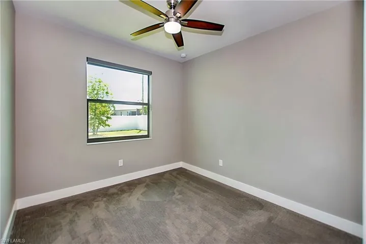 Carpeted empty room with ceiling fan