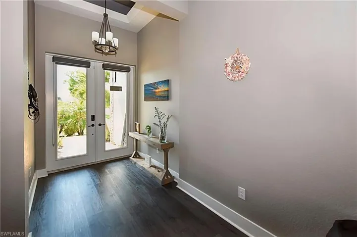 Foyer entrance featuring dark hardwood / wood-style floors, french doors, and a wealth of natural light