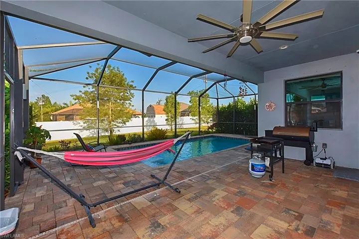 View of swimming pool with a patio area, a lanai, and ceiling fan