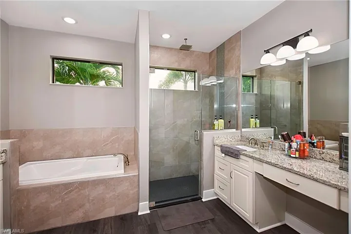 Bathroom featuring vanity, separate shower and tub, and hardwood / wood-style flooring