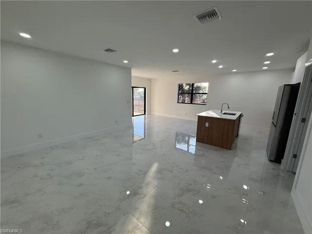 Unfurnished living room with recessed lighting and light marble finish floors