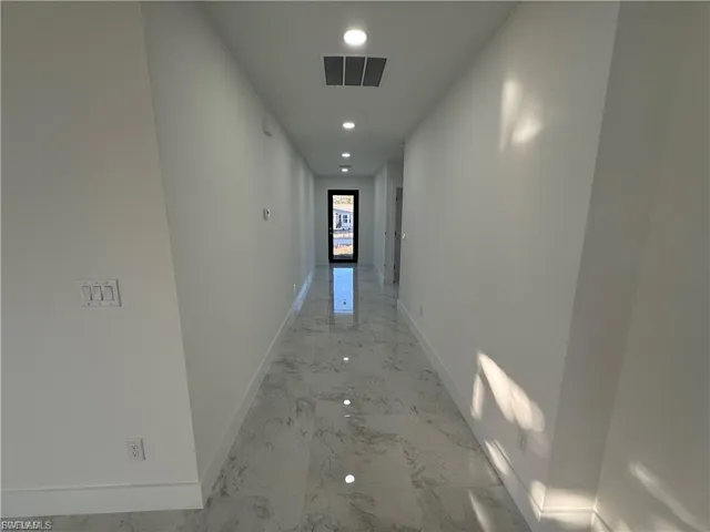 Corridor with recessed lighting and light marble finish flooring