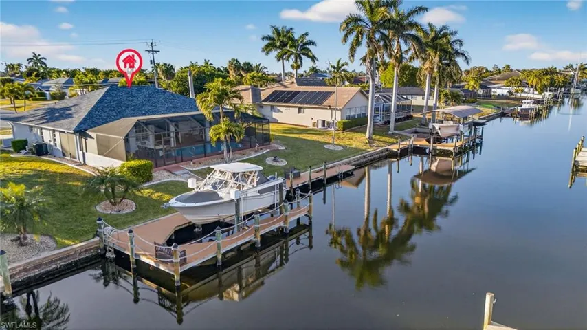 Dock area featuring a lanai, boat lift, a sunroom, and a water view