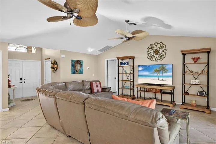 Living room with light tile patterned flooring and ceiling fan