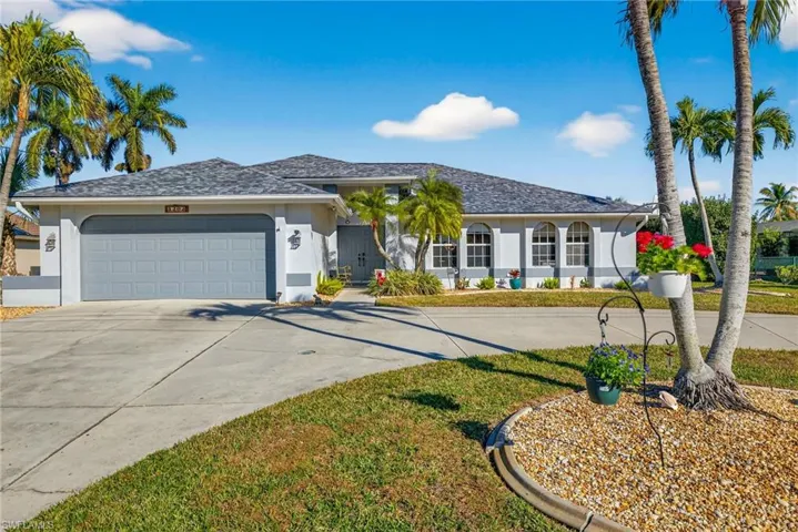 Single story home with concrete driveway, stucco siding, a garage, and a front lawn