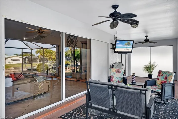 Sunroom / solarium featuring a ceiling fan, outdoor dining area, and a patio