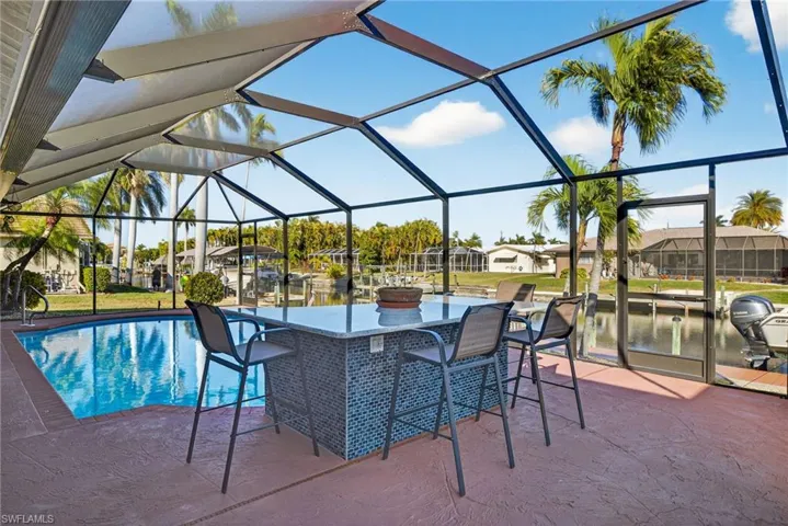 Outdoor pool featuring glass enclosure, a residential view, a sunroom, and a patio