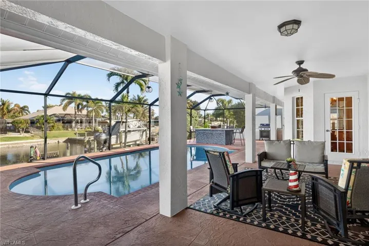 Swimming pool with a lanai, a patio area, a sunroom, an outdoor hangout area, and area for grilling