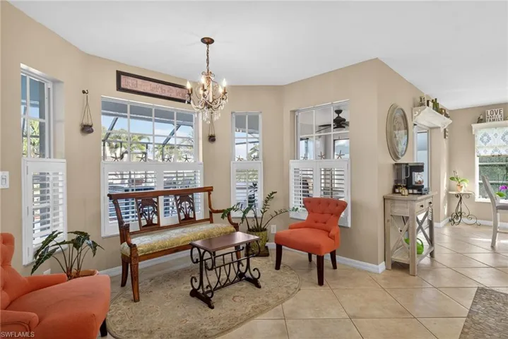 Living area featuring hanging lights, light tile patterned flooring, and a ceiling fan