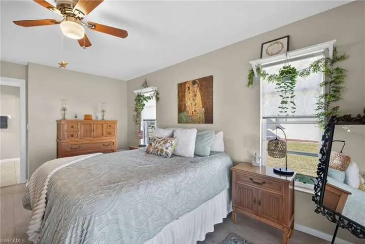 Bedroom featuring multiple windows, wood finished floors, and ceiling fan