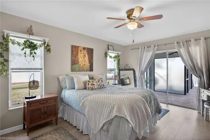 Bedroom featuring wood finished floors, ceiling fan, and access to outside