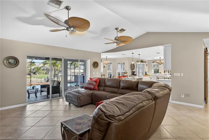 Living area with suspended lighting, ceiling fan, and light tile patterned flooring